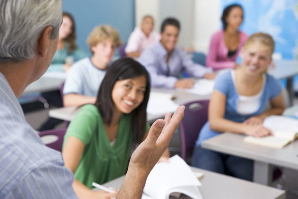 Schoolchildren in high school class listening to teacher