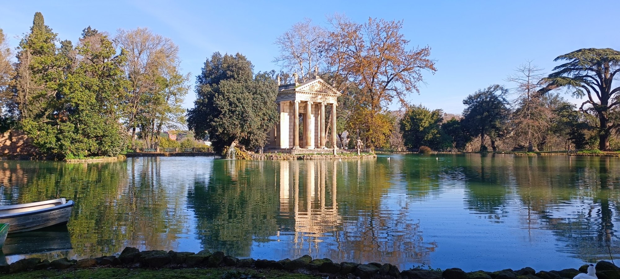 I dieci luoghi più romantici di Roma Veduta del laghetto di Villa Borghese con il Tempio di Esculapio riflesso sull'acqua, circondato da alberi