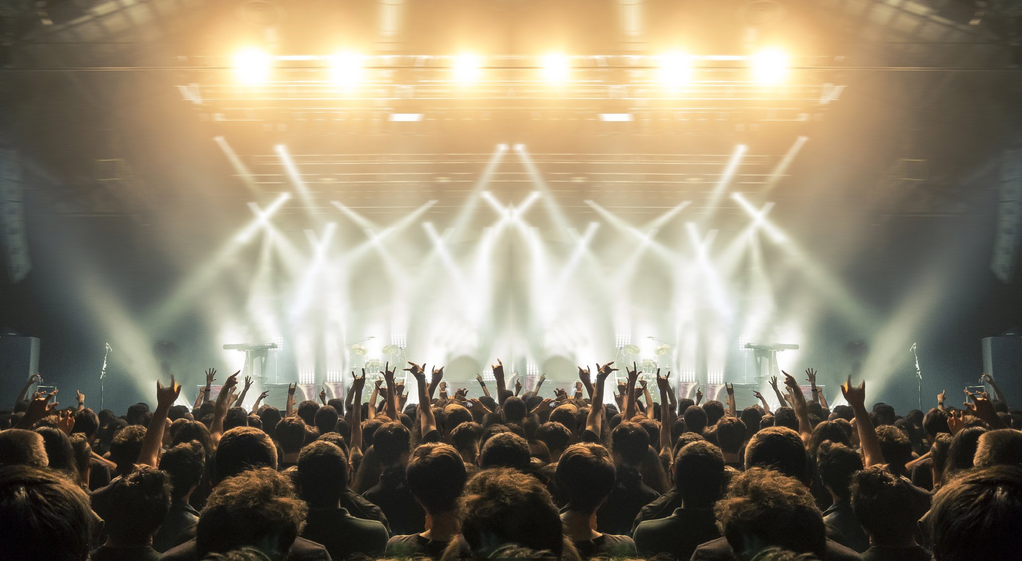 Raf posticipa il tour al 2027: la nuova data al Palazzo dello Sport di Roma Concert wide arena with happy fans clapping.