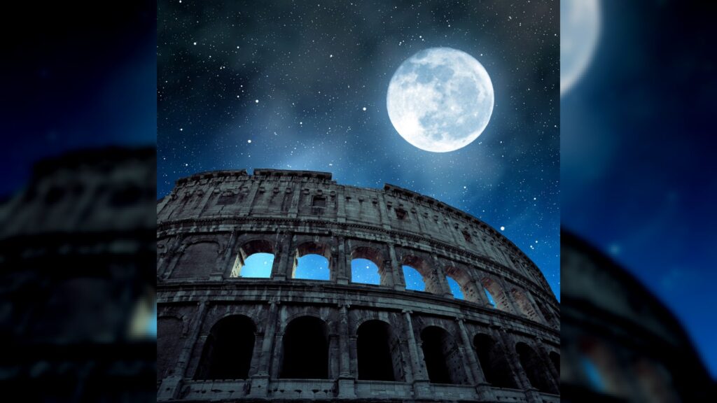 Flavian Amphitheatre or Colosseum in Rome with night sky and moon in the background, Italy.